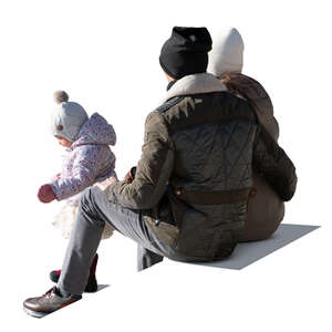 cut out family with a small child sitting outside in winter