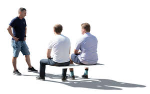 three cut out backlit men sitting and talking