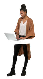 cut out woman standing by a table and working with a laptop