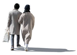 cut out sidelit couple in light spring coats walking