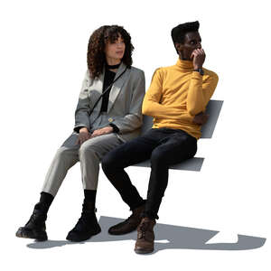 two cut out people sitting on a bench outside