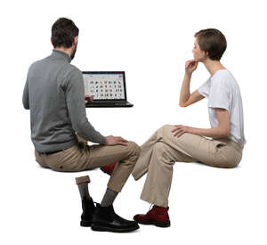 two cut out people sitting at a desk with computer