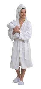 cut out woman in a white spa bathrobe and carrying towels walking