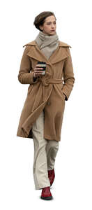 cut out woman in a brown overcoat walking and drinking coffee