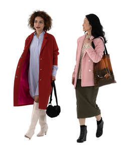 two cut out women wearing overcoats walking