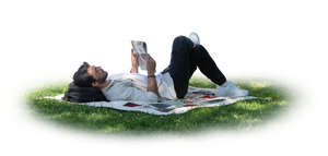 cut out man lying in the tree shade on the grass and reading a newspaper