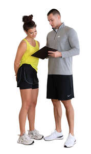 cut out woman in a gym talking to her personal trainer