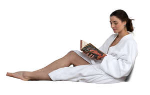 cut out woman in a bathrobe lying on bed and reading a book