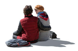 cut out backlit couple in autumn sitting seen from back angle