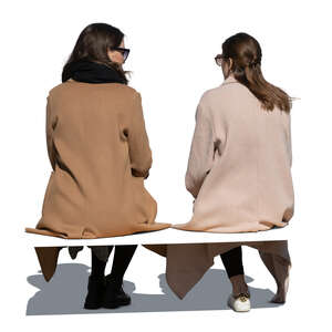 two cut out women in overcoats sitting and talking