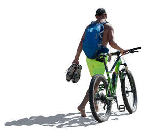 cut out man with a a bike walking on the seaside barefoot