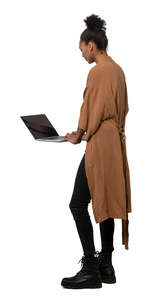 cut out woman standing at a table and working with a laptop