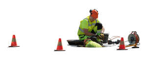 two cut out workmen working in the manhole on the street