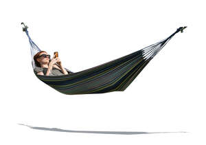 cut out woman lying in a hammock and reading from her phone