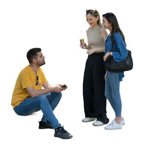 cut out man sitting and talking to two women standing beside him