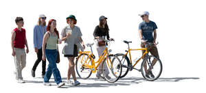cut out backlit group of teenagers with bikes walking and talking