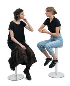 two cut out women sitting on barstools and talking
