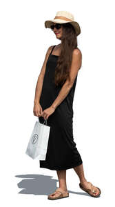 cut out woman in a black summer dress and hat and holding a shopping bag standing