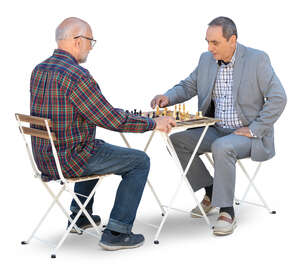 two cut out older men sitting and playing chess
