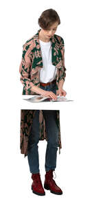 cut out woman standing and reading a magazine at the table