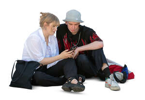 cut out man and woman sitting on the ground and watching smth from a smartphone
