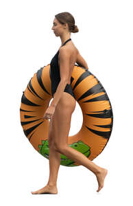 cut out woman with a big swim ring walking on the beach