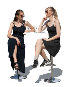 two cut out women sitting at an outdoor bar table and talking