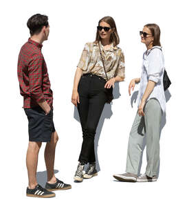 man talking to two girls standing and leaning on a railing