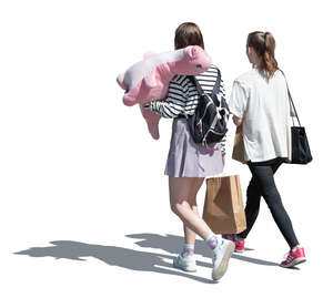 two young women with a big pink dinosaur plush toy walking