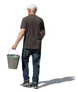 older man with a bucket walking in the garden