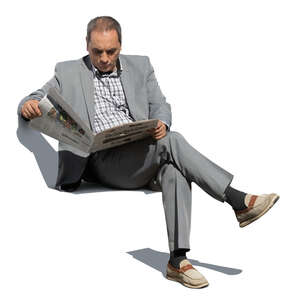 older man in a grey suit sitting and reading a newspaper