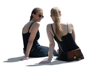 two backlit women sitting and talking seen from back angle