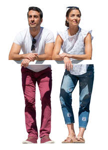 man and woman standing up on a balcony and leaning on a railing