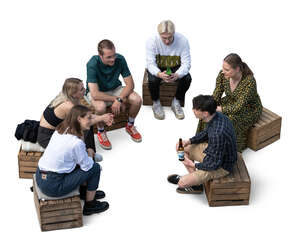 group of young people sitting on wooden crates