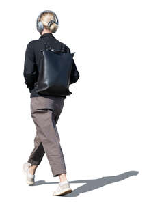 cut out woman with headphones walking on the street