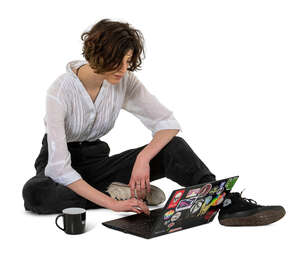 young woman sitting on the ground and working with laptop