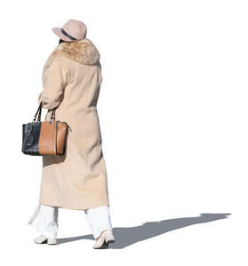 lady in a coat and wearing a hat walking in autumn