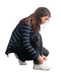 woman squatting and tying her shoe laces