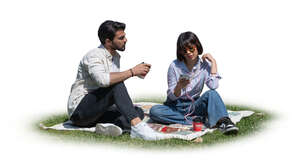 two people sitting in the park on the grass and drinking coffee