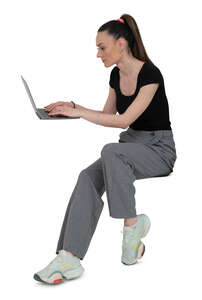 woman sitting at a desk and writing on a laptop