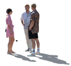 backlit group of three young people in summer standing and talking