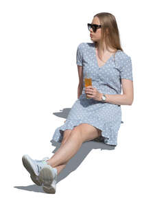 woman sitting outside in summer and drinking lemonade