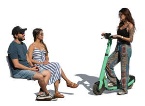 woman with a scooter standing and talking to two people sitting