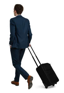 man in a suit and carrying a suitcase walking