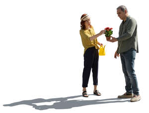 backlit older couple going to plant some flowers in the garden