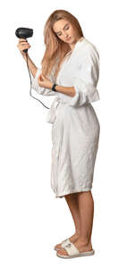 woman in a bathrobe standing and drying her hair