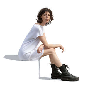 woman in a white dress and wearing black boots sitting