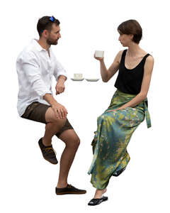 man and woman sitting at a bar table and drinking coffee