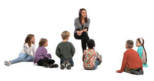 group of children stting on the ground and listening to their teacher