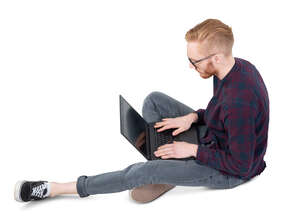 man sitting on the ground and working with a laptop